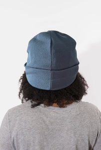 Person wearing a Satin Lined blue beanie with a white background